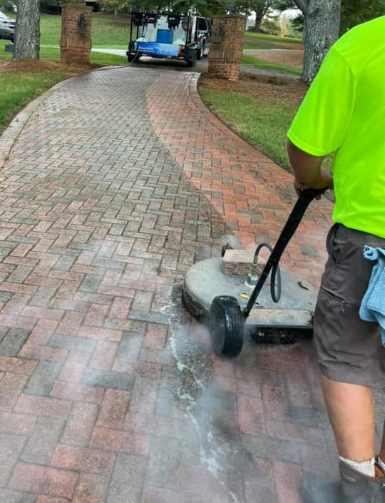 Surface cleaning a brick paver walkway through a landscaped lawn