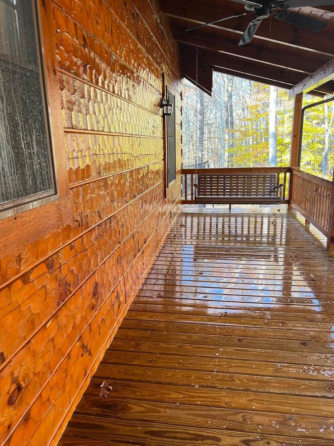 A freshly cleaned cabin porch, the tongue and groove ceiling and decking still wet